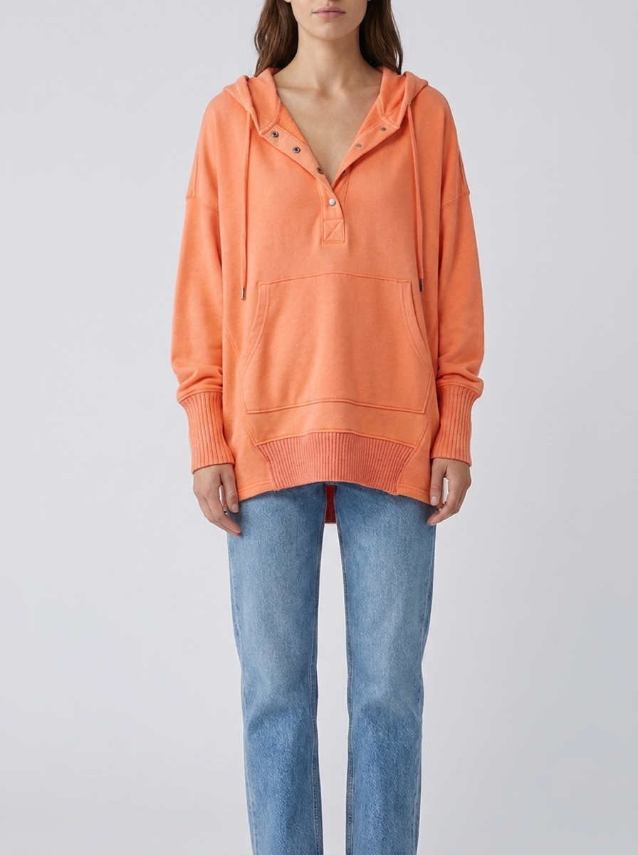 Woman wearing coral orange oversized hooded drawstring tunic top