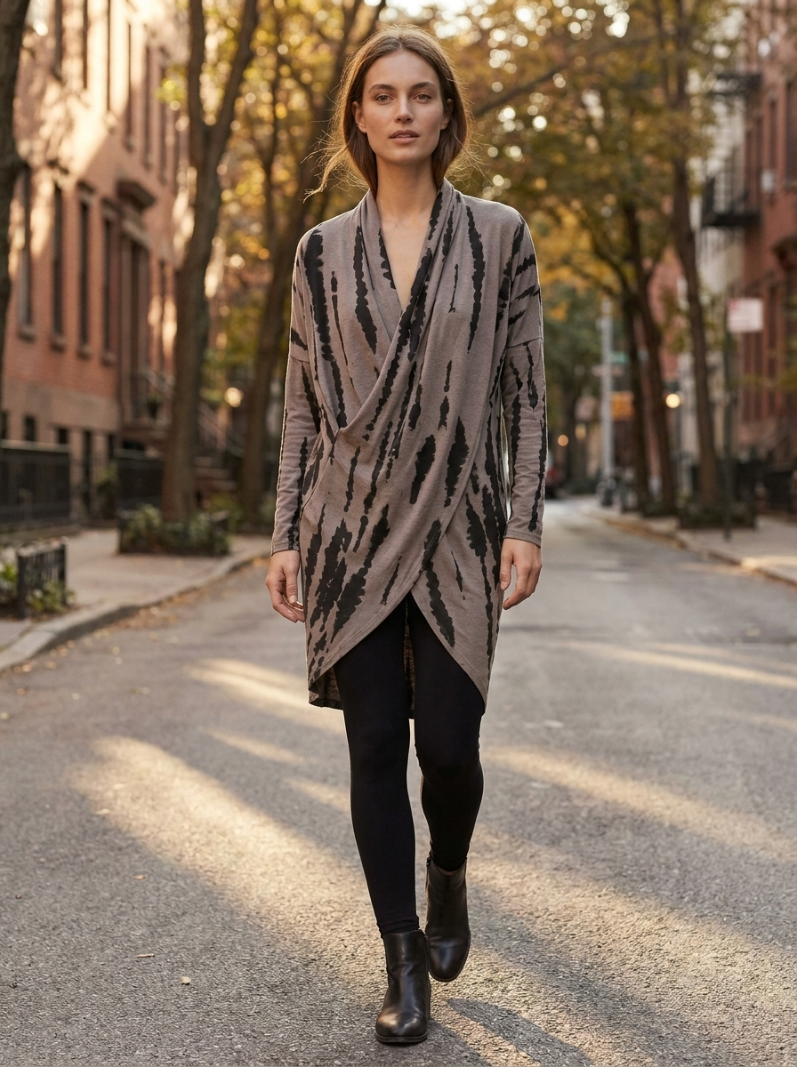 Woman walking a city street at golden hour in an abstract-print wrap tunic