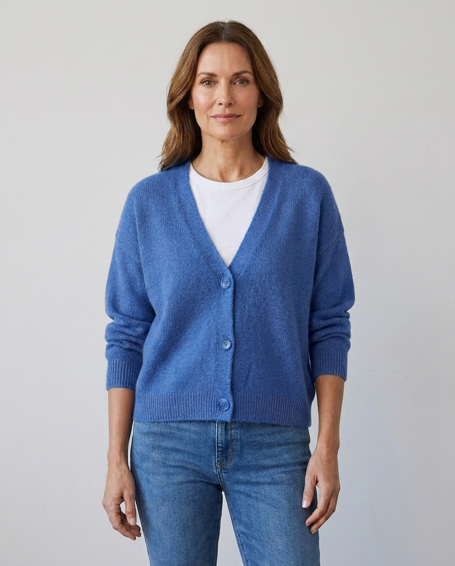 Women's relaxed knit button-front V-neck cardigan in blue, worn over a white tee with jeans