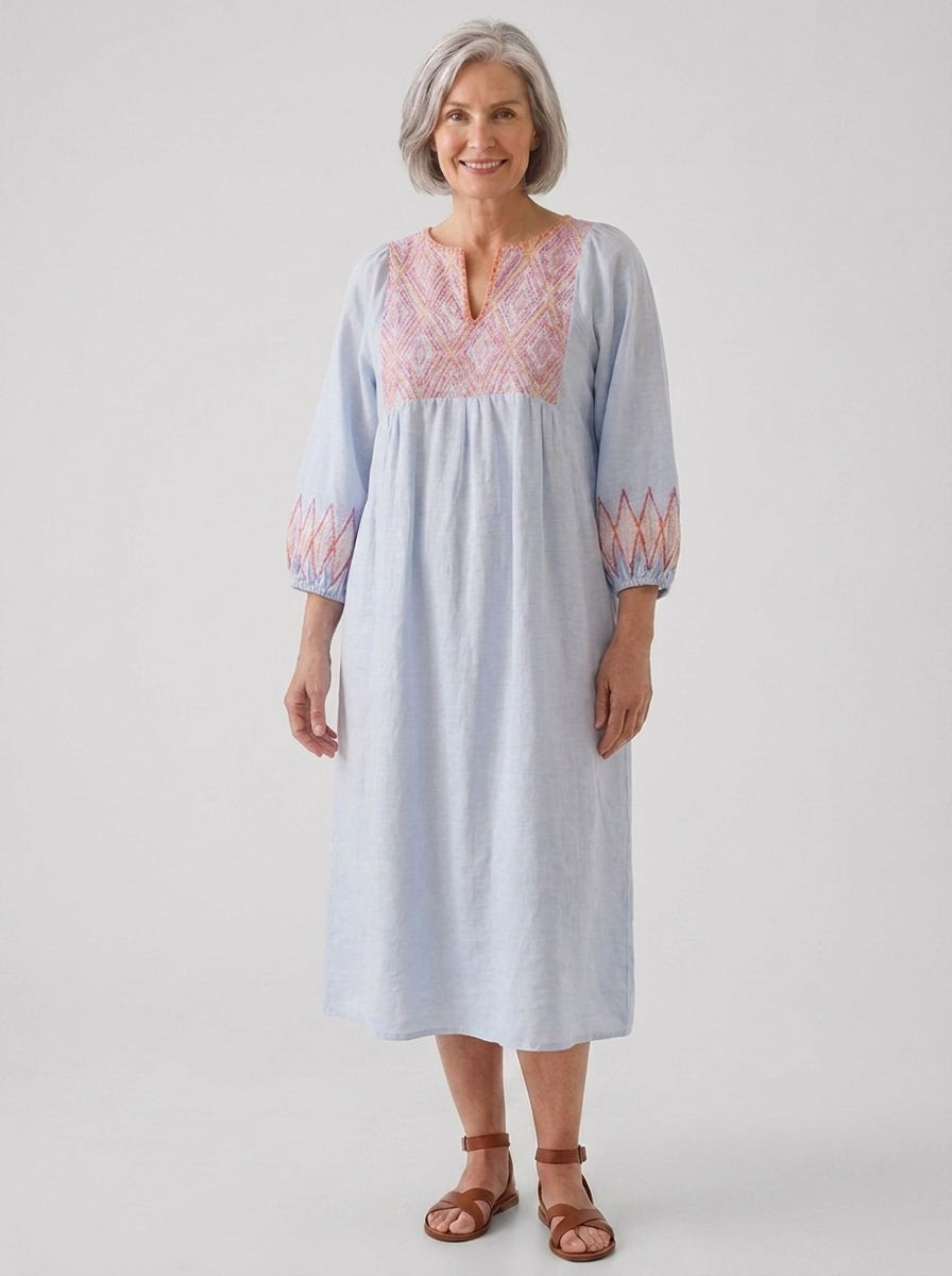 Woman wearing pale blue embroidered V-neck long-sleeve linen midi brunch dress, Purple colorway, full-body studio